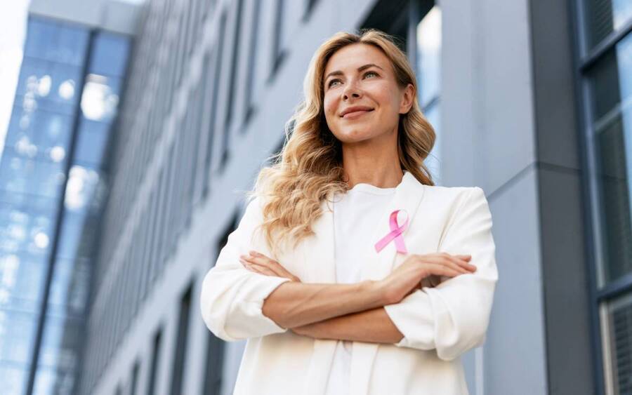 Woman wearing a pink ribbon for breast cancer awareness.
