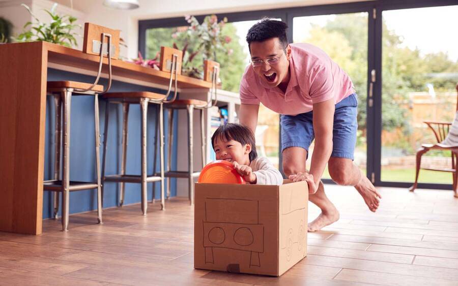 A father and son playing  make believe in the kitchen, illustrating a healthy father and son spending time together.