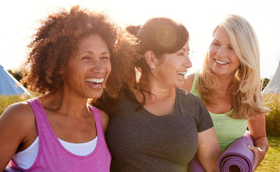 The three diverse women show how a healthy lifestyle including spending time at an outdoor yoga session can help prepare for menopause.