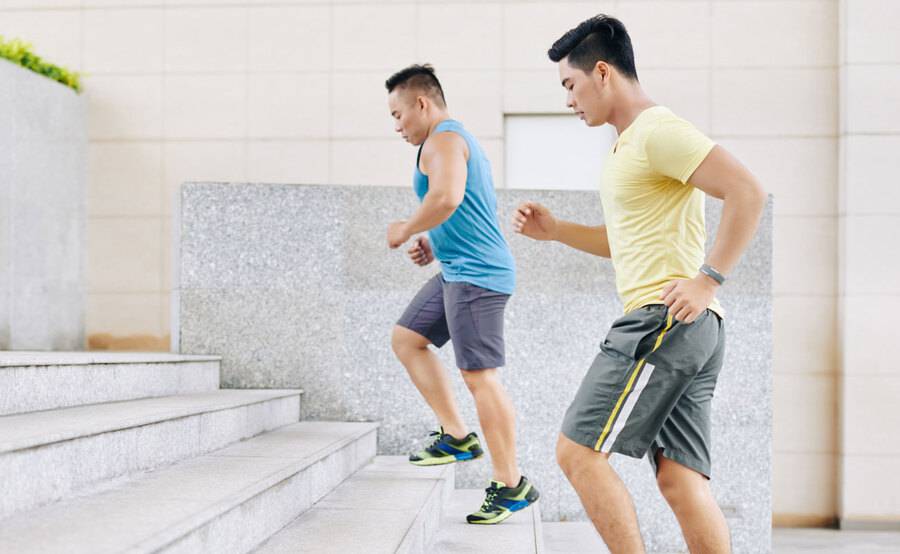 Two younger men run up the stairs as part of their fitness routine to stay healthy.