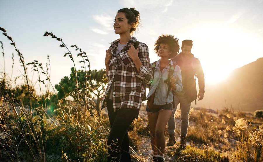 Three young people enjoy a hike outdoors.