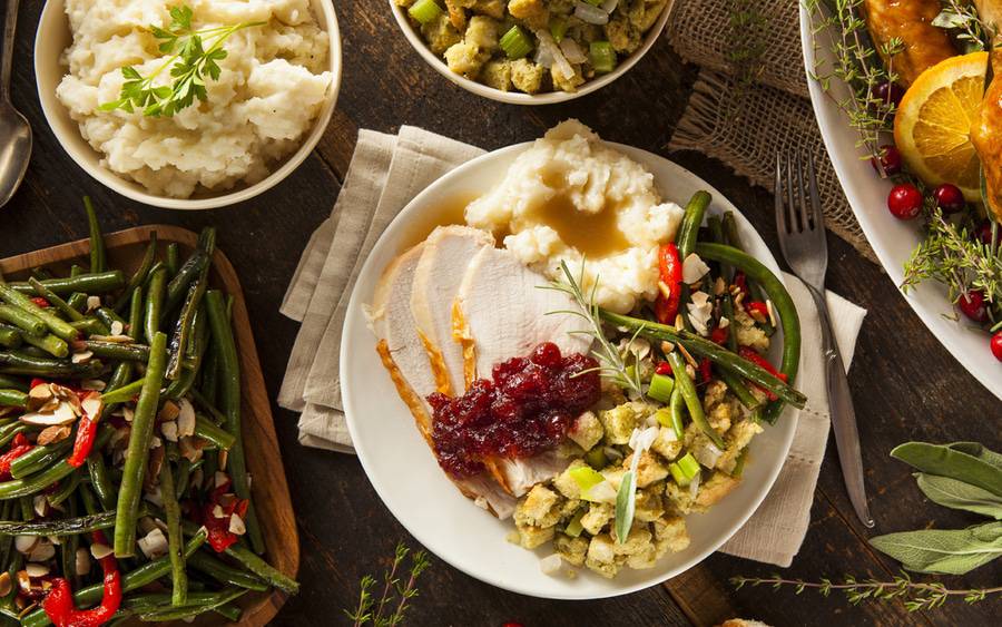 A plate full of turkey, stuffing, mash potatoes and green beans.