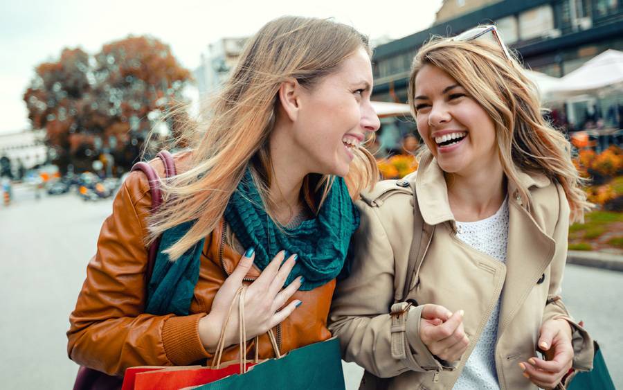 Two women shopping and having fun, showing how to keep your holidays season joyful.