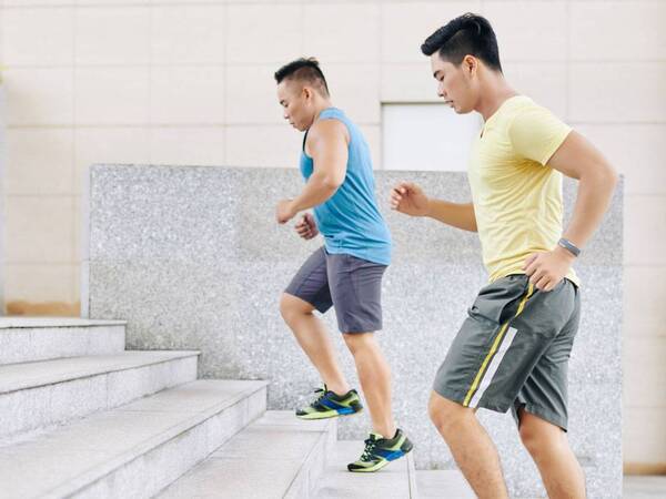 Two younger men run up the stairs as part of their fitness routine to stay healthy.