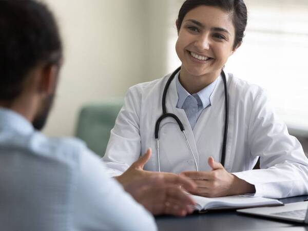A cancer specialist meets with a patient to discuss the screenings available for detecting cancer.