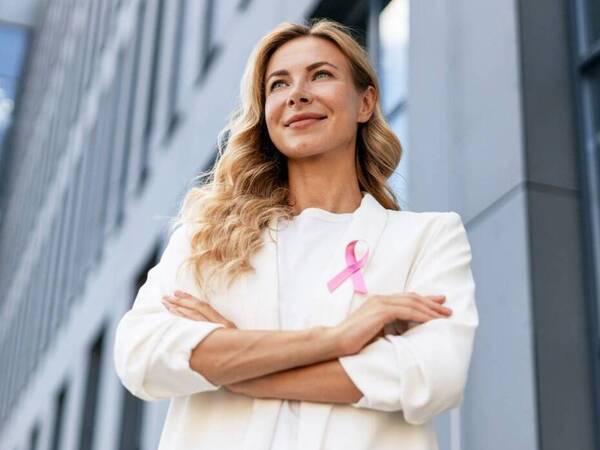 Woman wearing a pink ribbon for breast cancer awareness.